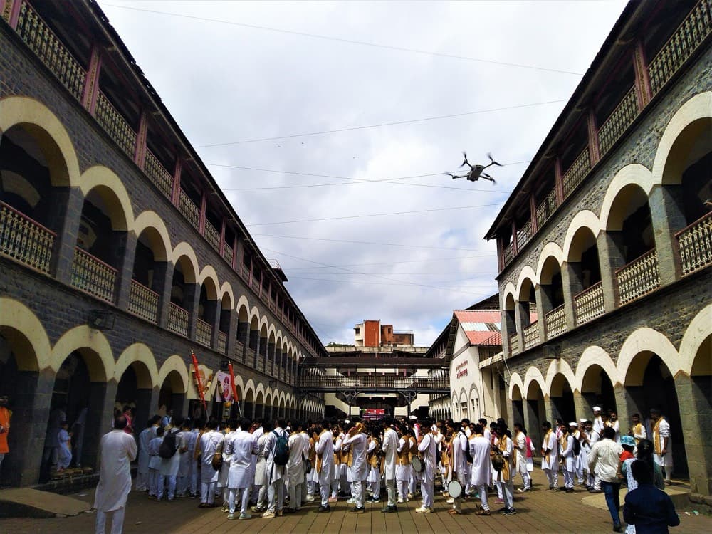 A dhol-tasha pathak assembling in a Pune school courtyard before miravnuk